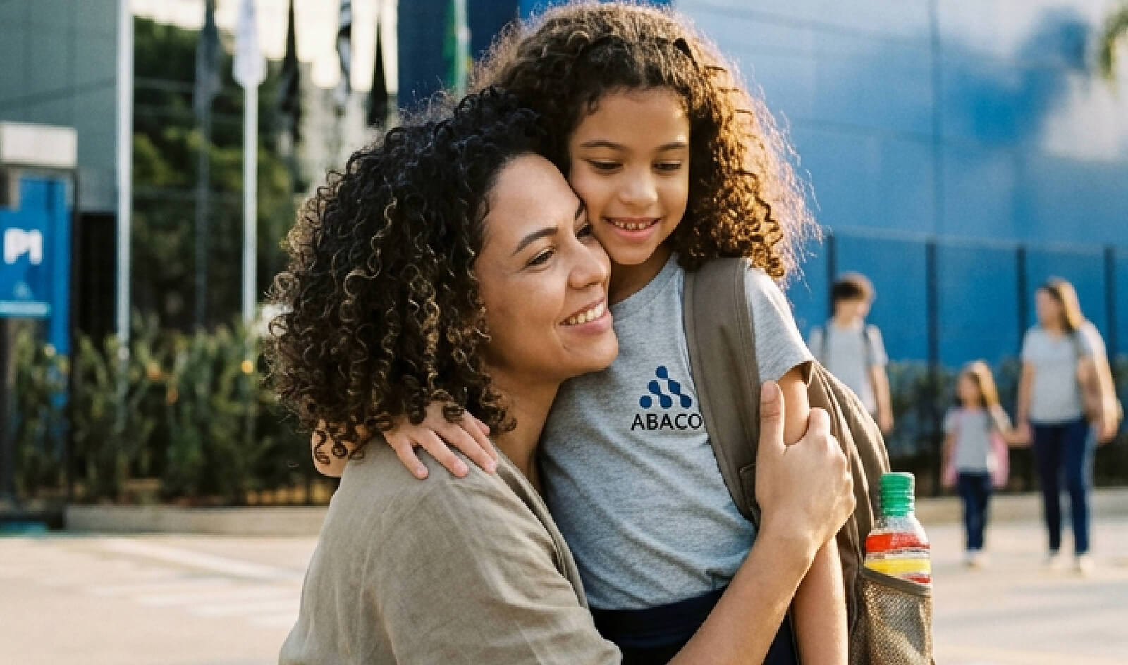 Mãe Abraçando a filha na porta do colegio abaco